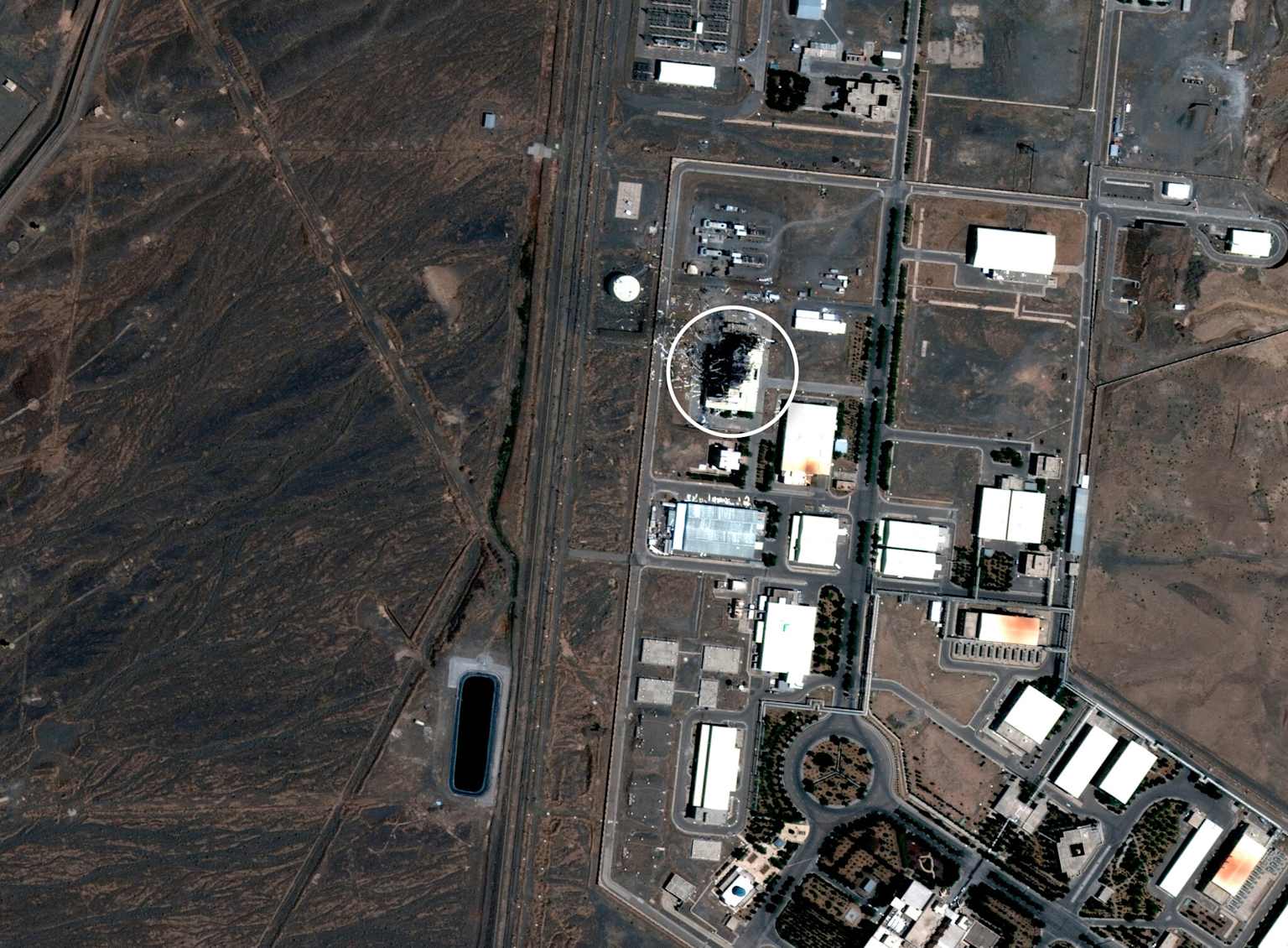 Aerial view of Iran's Natanz nuclear facility, showing its extensive infrastructure and a highlighted area of damage or construction.