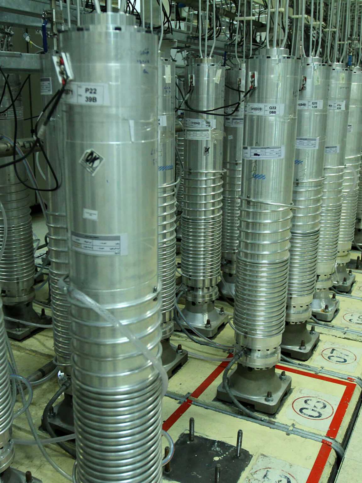 A row of gas centrifuges used for uranium enrichment in a nuclear facility, demonstrating the industrial scale of the process.