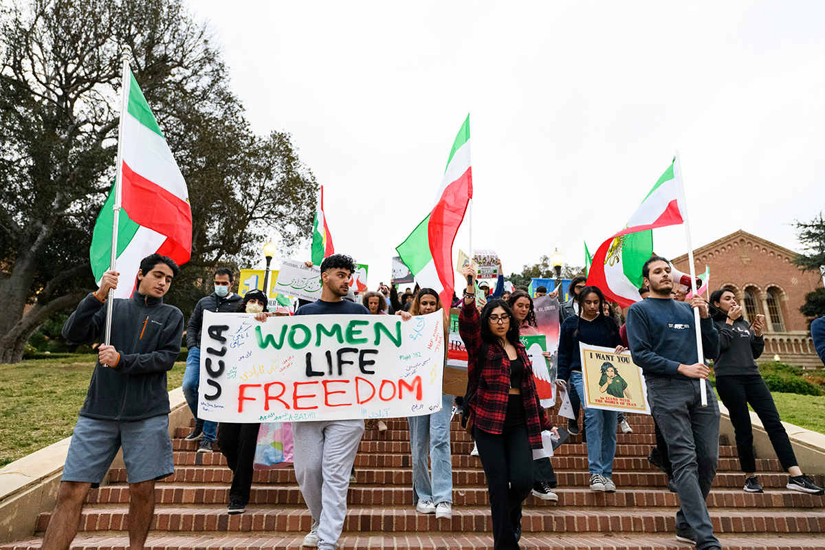 UCLA students hold Iranian flags and signs supporting the "Women Life Freedom" movement during a protest rally.