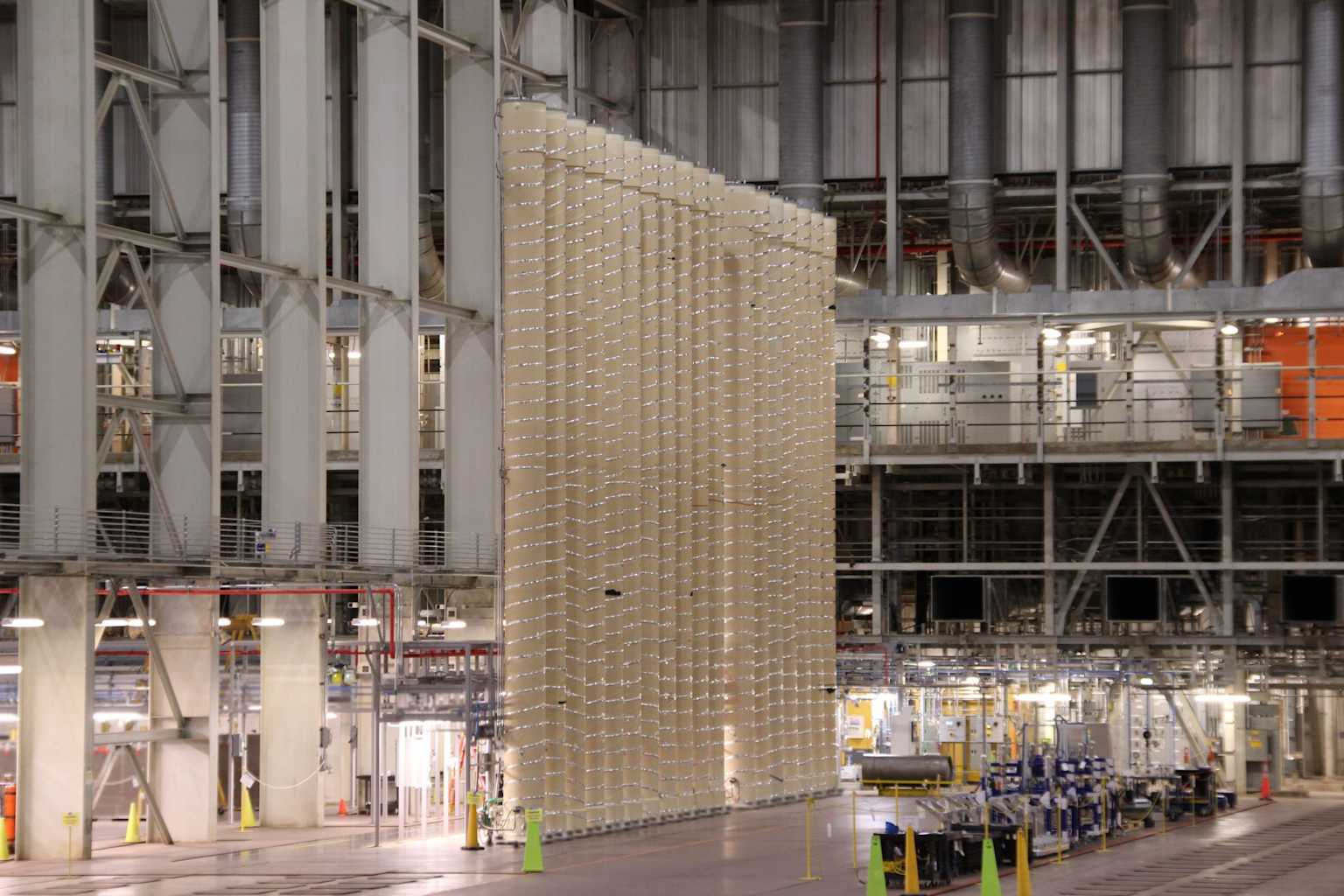 A large-scale gas centrifuge cascade within an industrial hall, demonstrating the setup for uranium enrichment.