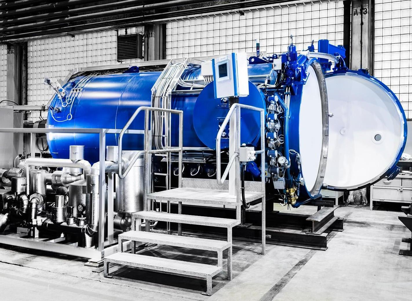 Large blue industrial processing unit, likely a desublimer or regasification vessel, used in uranium conversion.