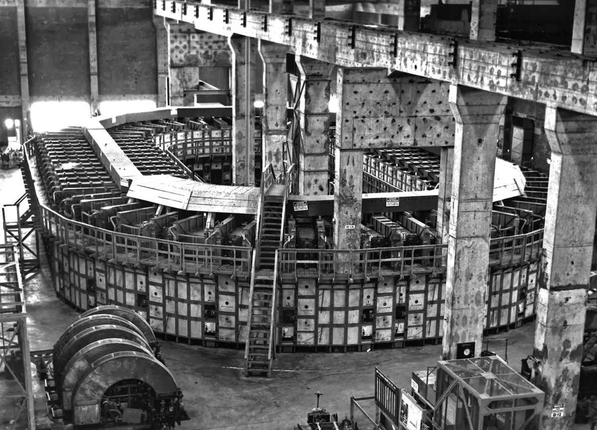 An interior view of a Calutron facility, showcasing the circular arrangement of units used for electromagnetic uranium isotope separation.
