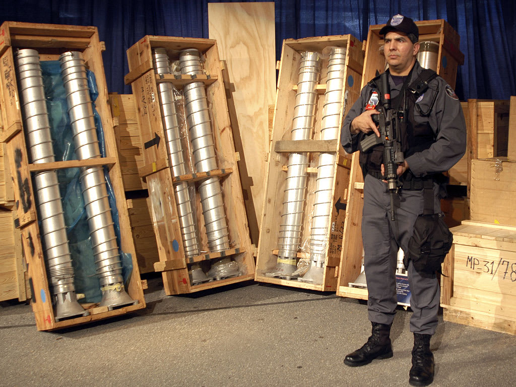 Security personnel guard centrifuge components, typical of those supplied by the A.Q. Khan network, from Libya's dismantled nuclear program.