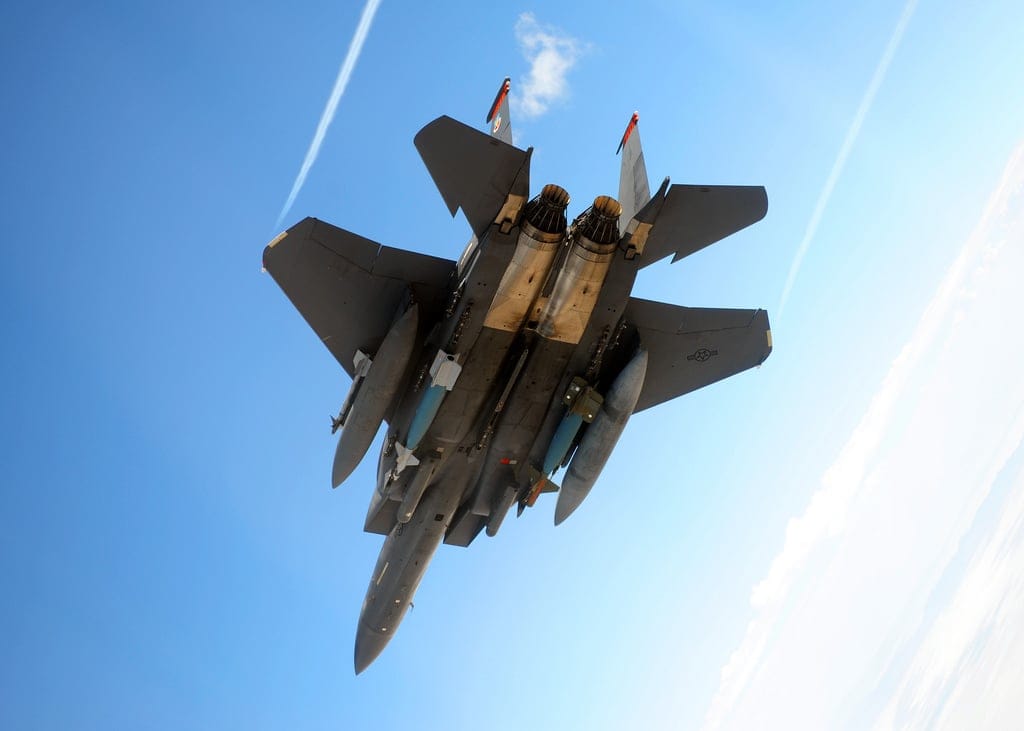 An F-15 Strike Eagle aircraft carrying GBU-28 Paveway III bunker buster bombs, illustrating a key munition for striking hardened targets.