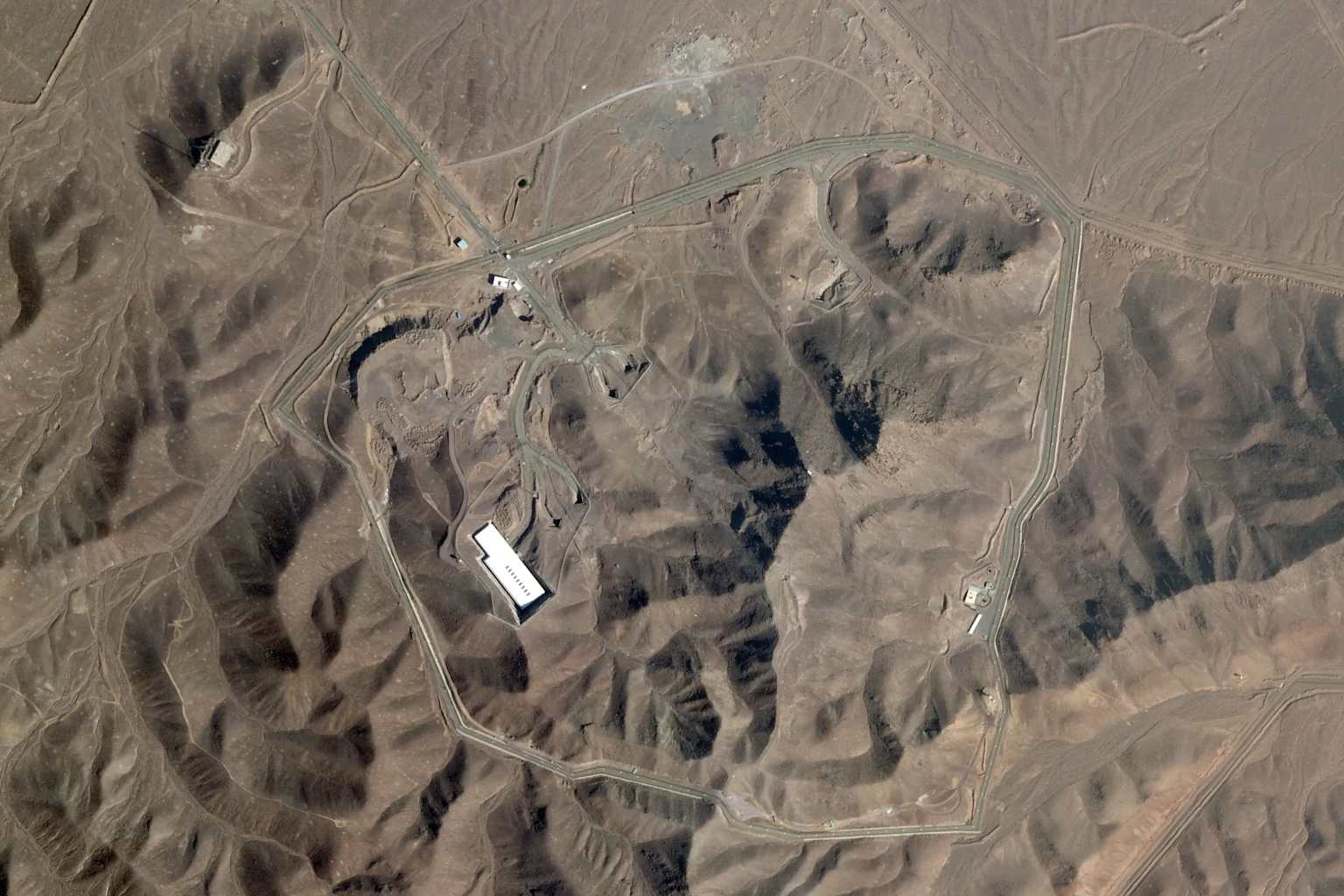 Satellite view of the Fordow Fuel Enrichment Plant in Iran, showing its layout and key structures within the arid landscape.