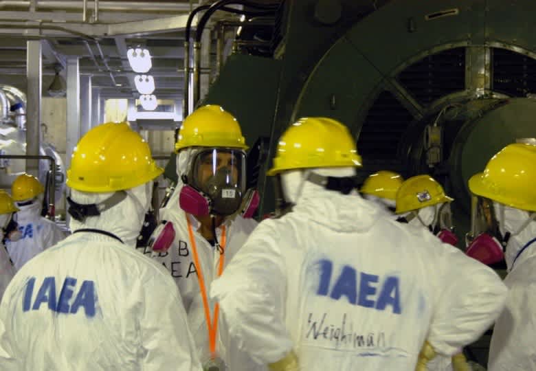 IAEA inspectors wearing protective gear during an inspection at a nuclear facility.
