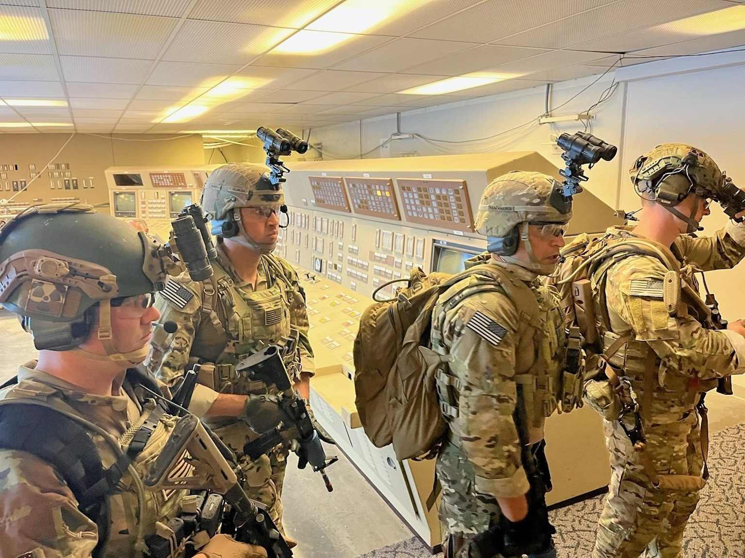 Armed security personnel conducting a training exercise inside a nuclear facility control room, demonstrating nuclear facility hardening and civilian nuclear security measures.